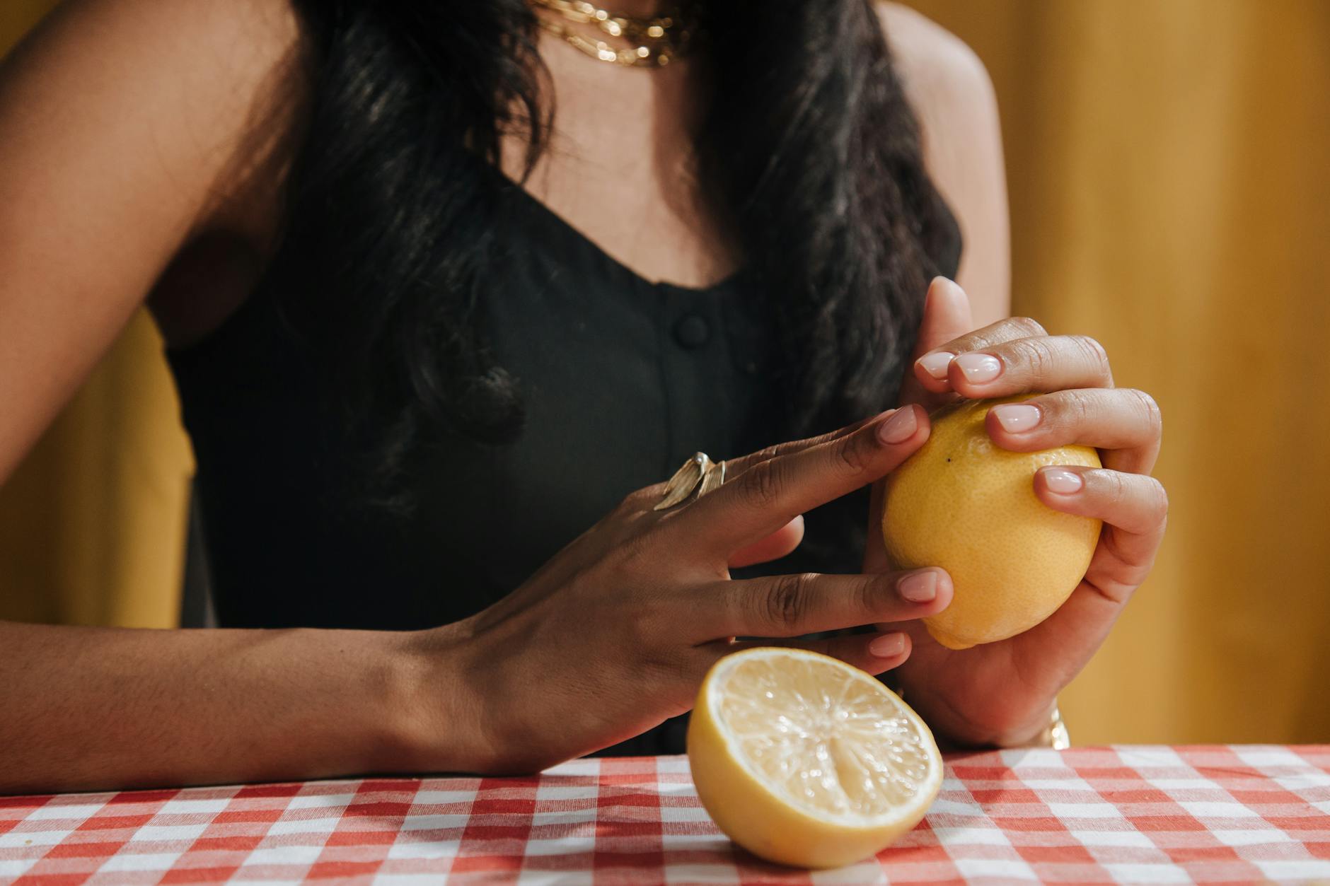 Yellow silicone clitoral vibrator surrounded by fresh fruit on bright background