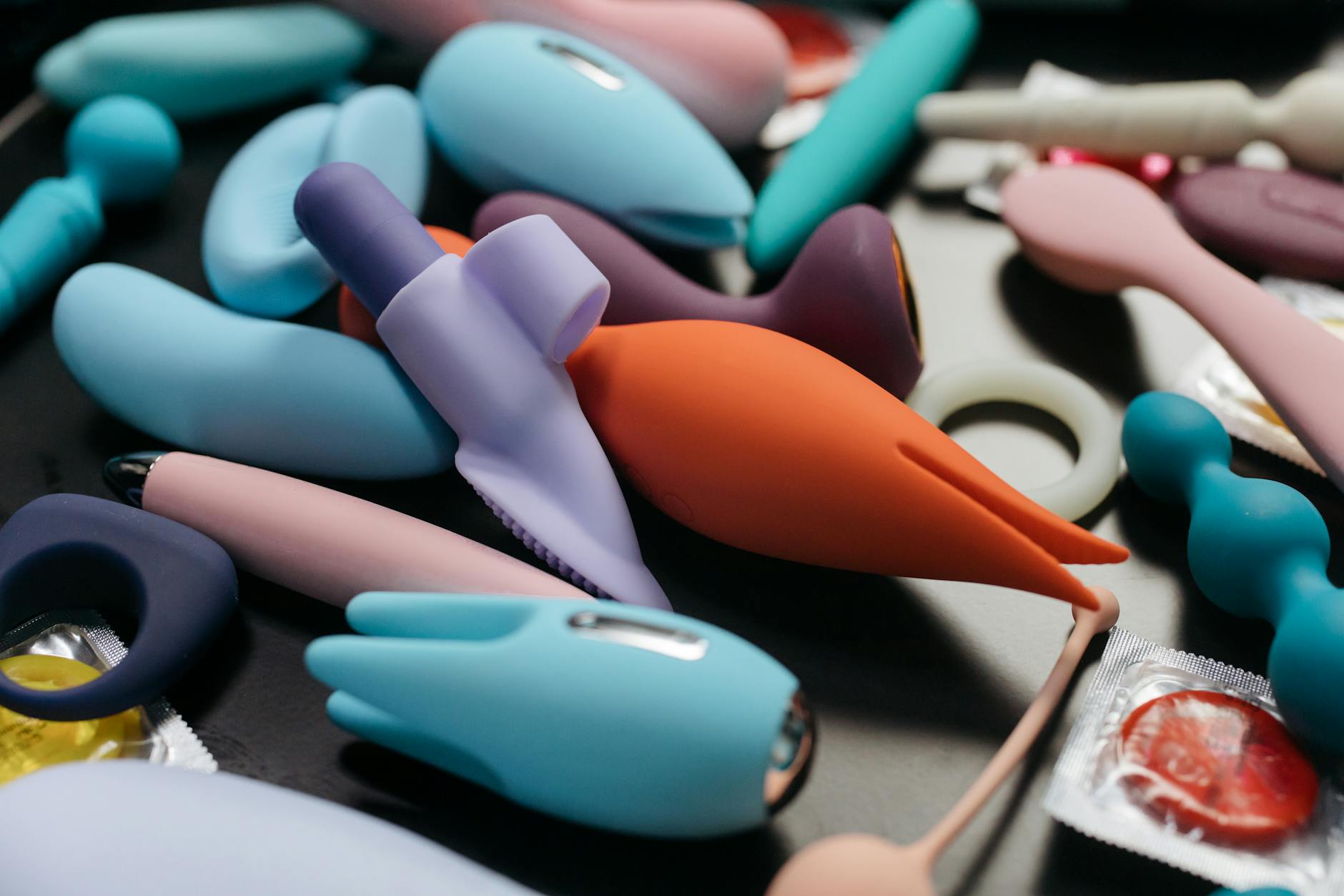 Close-up view of vibrant adult toys including clitoral vibrators and massage devices.