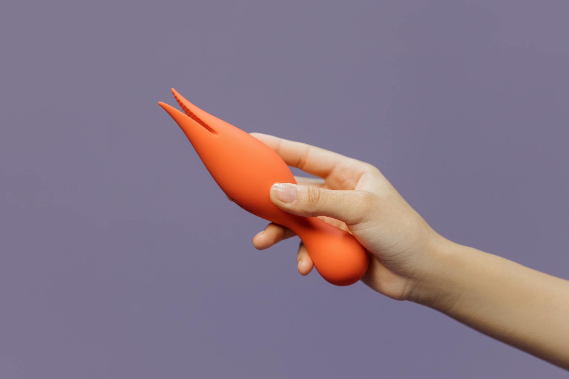 Close-up of hands holding a lemon vibrator against skin, demonstrating careful application technique