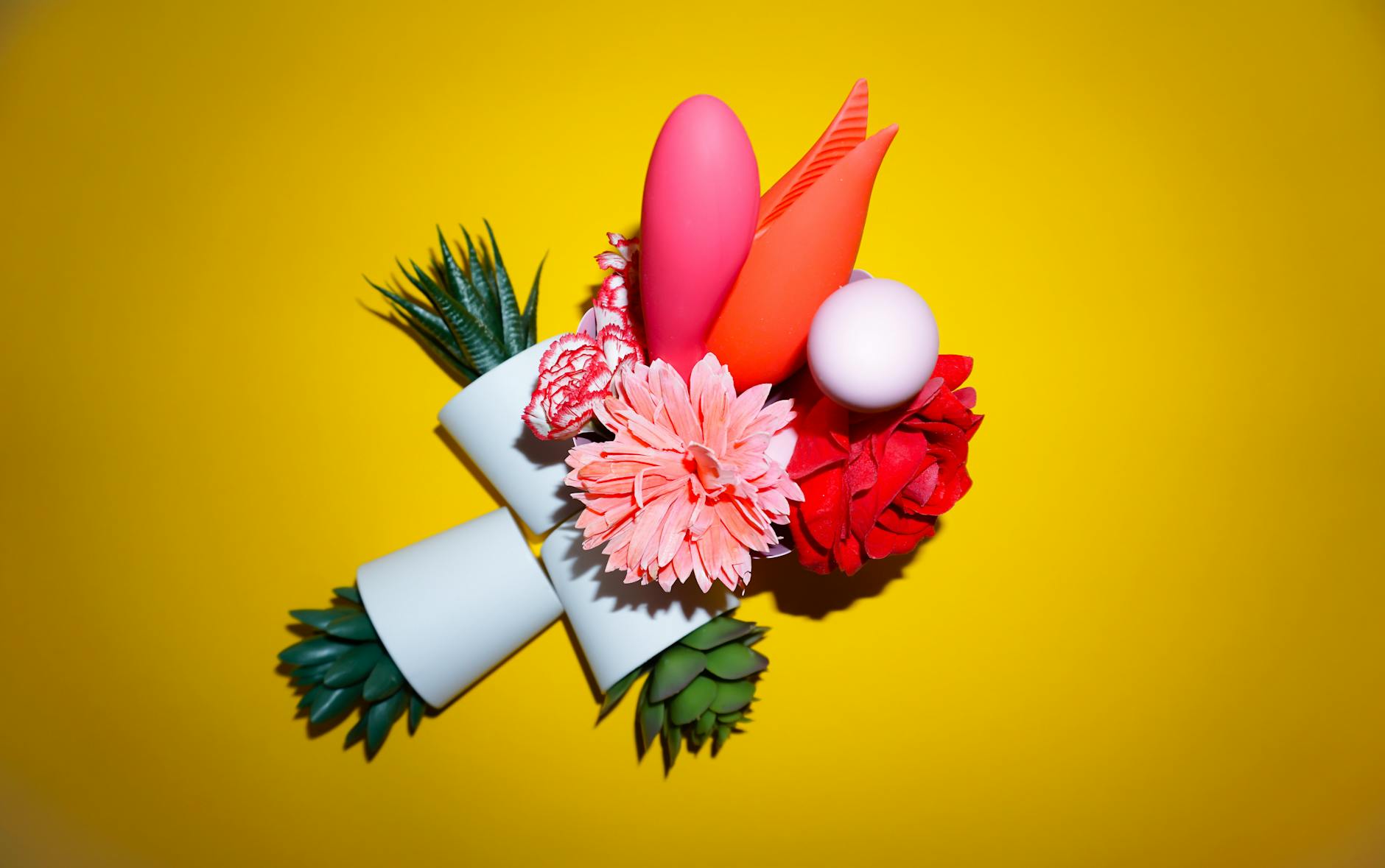 A hand holding a fresh lemon on a pink background, symbolizing freshness and wellness.